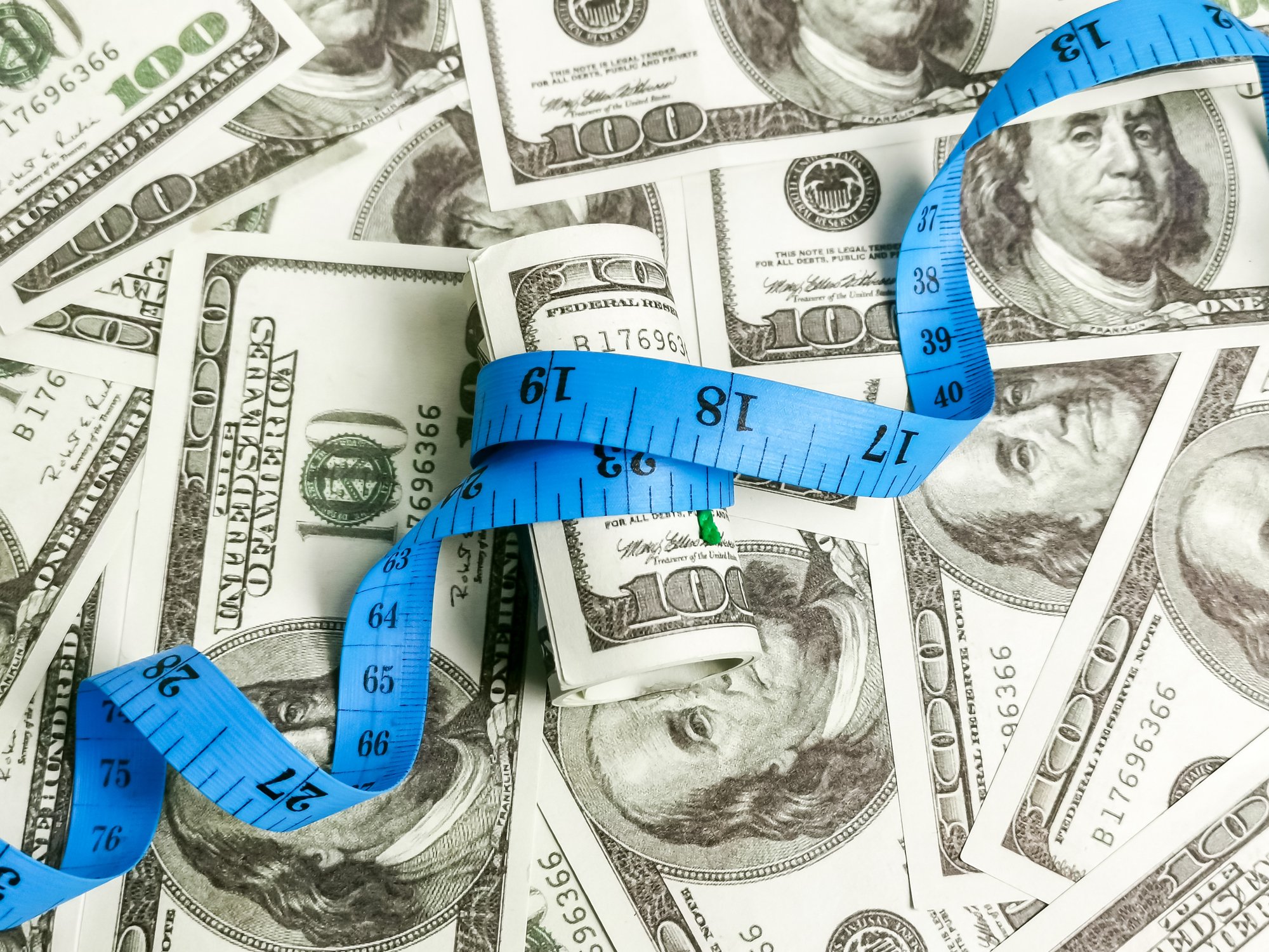Measuring tape on top of cash